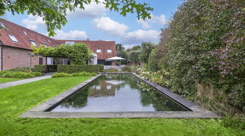 In deze weelderige tuin in Boutersem ontbrak een waterpartij, vonden de eigenaars. Tuinwerken Willemsens tekende hier een zwemvijver met een rechthoekige zwemzone - waar je vlot baantjes kan trekken - en een filterzone in vrije, organische vorm met onder meer waterlelies. De zwemvijver vormt de blikvanger van de tuin.