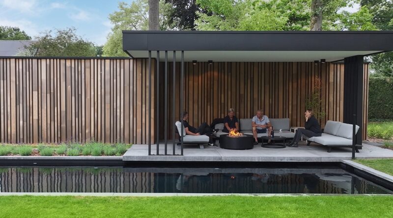 Aan de rand van een bosrijke tuin met zwemvijver realiseerde Pieter Lens een modern, vrijstaand poolhouse dat natuurlijke materialen combineert met een strak architecturaal lijnenspel. De gevelbekleding in cederhout, met wisselende breedtes en terugliggende zwarte aluminium profielen, creëert een boeiend ritme dat perfect opgaat in de omgeving.